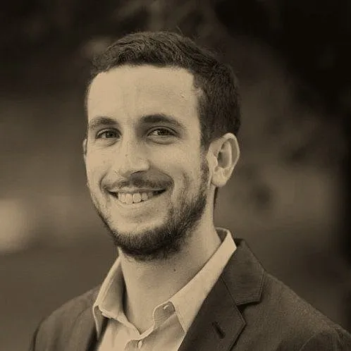 Paul Kuhne, smiling, in a light shirt and jacket.